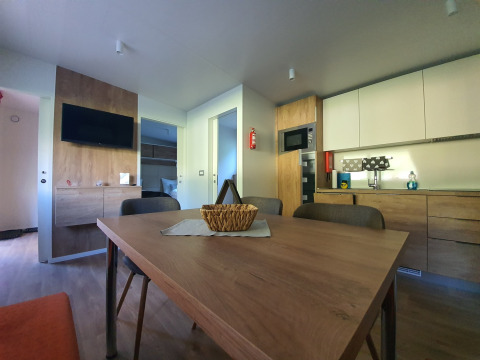 Hébergement glamping moderne avec table à manger, cuisine et TV chez HochOBEN - Stacaravans, Autriche.