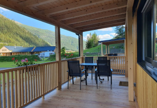 Veranda de madera en HochOBEN - Stacaravans Oostenrijk con vistas a montañas y zona de camping en Austria.
