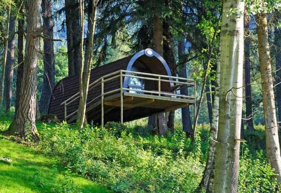 Cabaña moderna de madera sobre pilotes en el bosque en Nature Resort Natterer See - Woodlodges Tirol, ideal para glamping.