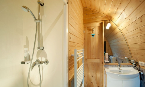 Modern bathroom with wooden walls in Nature Resort Natterer See - Woodlodges Tirol, glamping style.