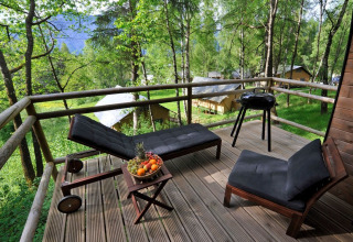 Glamping-accommodatie Nature Resort Natterer See - Woodlodges Tirol met terras, ligstoelen en barbecue.