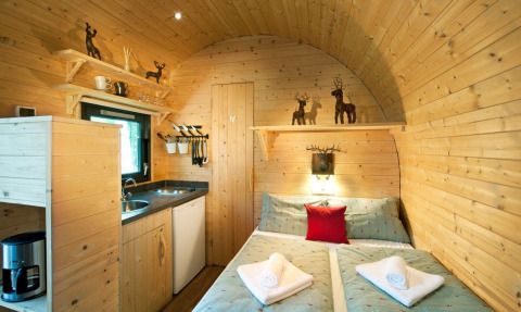 Alojamiento glamping de madera con cama doble y cocina en Nature Resort Natterer See, Tirol.
