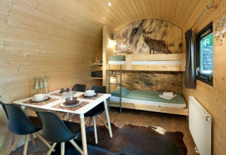 Interno di una Woodlodge al Nature Resort Natterer See, Tirolo, con letto a castello e tavolo da pranzo.