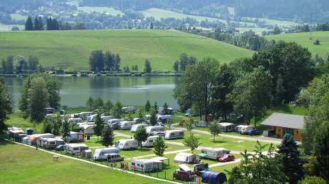 Camping Putterersee with cozy pods, caravans, and a scenic lakeside view in the Austrian countryside.