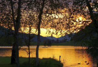 Sunset view over the lake at Camping Putterersee in Austria, ideal for cozy glamping pods or camping.