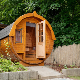 Round barrel-shaped wooden cabin at Natuurpark Camping Prinzenholz, glamping in Schleswig-Holstein nature.