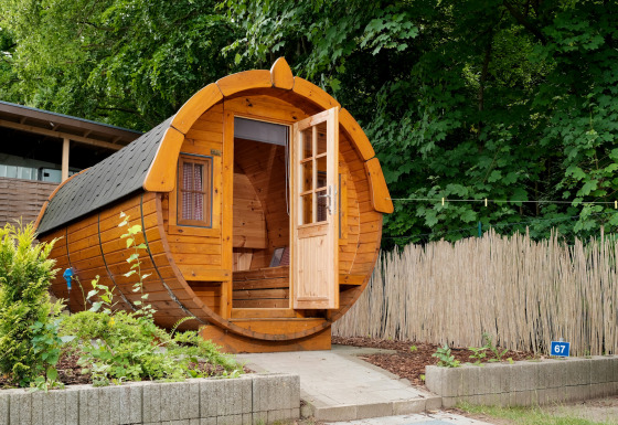 Rund trætønnehytte til glamping på Natuurpark Camping Prinzenholz i Sleeswijk-Holstein omgivet af natur.