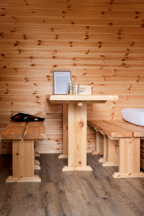 Cozy wooden interior with benches and table at Natuurpark Camping Prinzenholz, Schleswig-Holstein.