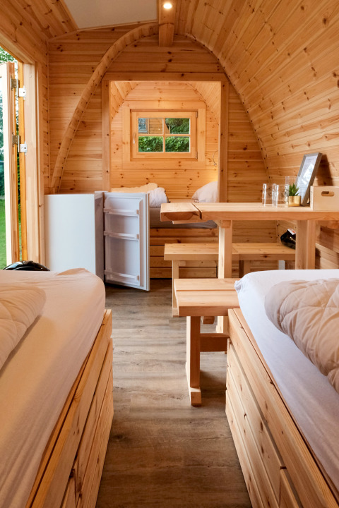 Binnenaanzicht van een houten glamping accommodatie bij Natuurpark Camping Prinzenholz, Schleswig-Holstein.