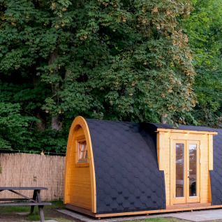 Glamping-accommodatie bij Natuurpark Camping Prinzenholz, houten pod en picknicktafel in groene natuur.