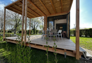 Outdoor terrace of a Strandcamping Podersdorf am See tiny house, Austria, with dining table and chairs.