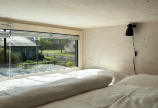 Udsigt fra en hyggelig seng inde i et Tiny House på Strandcamping Podersdorf am See, Østrig.