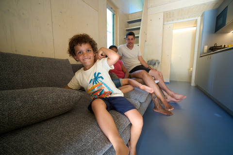 Una famiglia si rilassa in una moderna tiny house allo Strandcamping Podersdorf am See, in Austria.