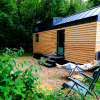 Woman relaxing outside a cozy tiny house in the woods, Tinyhouse KLEINES EMS-IDYLL in Emsland, glamping.