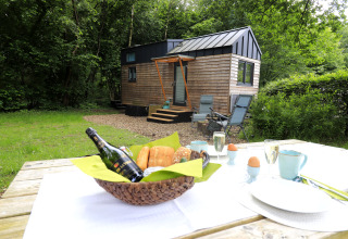 Glamping Tinyhouse KLEINES EMS-IDYLL in Emsland, met ontbijttafel buiten en uitzicht op het groen.