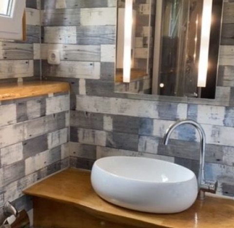 Salle de bain moderne dans un tinyhouse avec plan en bois, vasque et miroir, glamping au Heegermeer, Mecklembourg-Poméranie.