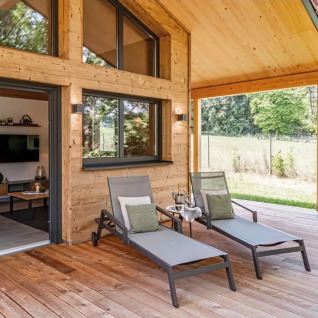 Træterrasse med liggestole ved luksuriøs glampingindkvartering Vital CAMP Bayerbach i Bayern, Tyskland.