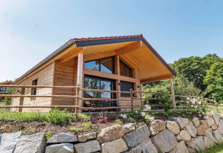Holzhütte Glamping Unterkunft bei Vital CAMP Bayerbach mit Steinen und terrassiertem Garten im Freien.