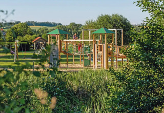 Parque infantil rodeado de naturaleza en Vital CAMP Bayerbach, glamping con casas de lujo en Baviera.