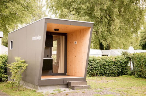 Moderna mini lodge al Campingpark Gohren in Baden-Württemberg, circondata dal verde del campeggio.