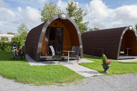 Glamping-Unterkunft in Nordsee Camp-Norddeich - Pods Oost-Friesland mit Fahrrädern und Sitzmöglichkeiten.