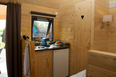 Gemütliches Glamping-Pod bei Nordsee Camp-Norddeich mit Kochnische, Holzwänden und einladender Stimmung.