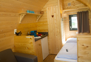 Interno di un'accogliente pod in legno con angolo cottura, letto e finestra al Nordsee Camp-Norddeich, Oost-Friesland.