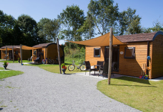 Wooden glamping pods at Nordsee Camp-Norddeich - Pods Oost-Friesland with bikes and sun shades outside.
