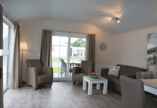 Hyggelig opholdsstue i glampingindkvartering på Nordsee Camp-Norddeich med moderne møbler og udsigt.