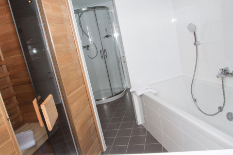 Salle de bain avec baignoire, douche et sauna dans l’hébergement glamping Nordsee Camp-Norddeich - Pods Oost-Friesland.