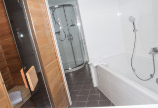 Badezimmer mit Badewanne, Dusche und Sauna in der Glamping-Unterkunft Nordsee Camp-Norddeich - Pods Oost-Friesland.