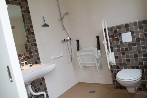 Bagno accessibile con doccia, sedile pieghevole, maniglioni e WC sospeso al Nordsee Camp-Norddeich.
