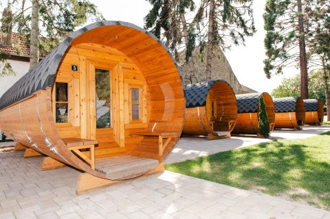 Unikke tøndeformede glampinghytter på Glamping wijnroute Bockenheim, Pfalz, omgivet af træer og natur.