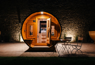 Round glamping accommodation shaped like a wine barrel on the Bockenheim wine route, Pfalz, lit at night.