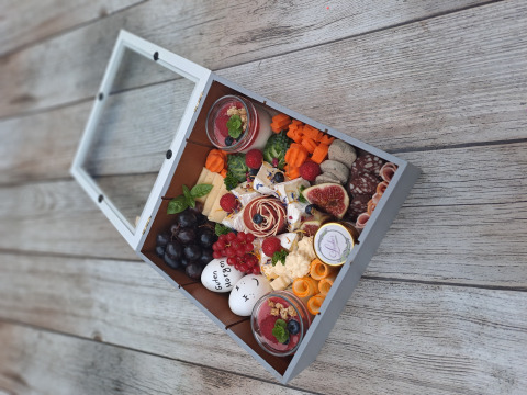 Feestelijke picknickdoos met kaas, vlees, fruit en desserts bij Rustieke wijnvaten Glamping Bockenheim, Pfalz.