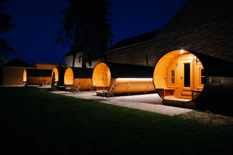 Alloggi glamping unici a forma di botti di vino, illuminati di notte presso la Wine Route Bockenheim, Pfalz.