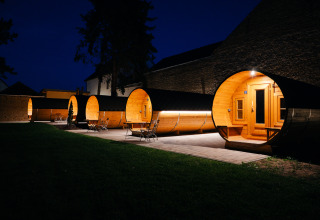 Alloggi glamping unici a forma di botti di vino, illuminati di notte presso la Wine Route Bockenheim, Pfalz.