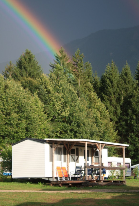 Glamping accommodation or camping at Camping Rosental Roz in Austria with a rainbow and forest view.