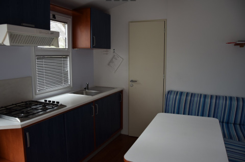 Interior of a glamping accommodation at Camping Rosental Roz - Stacaravans Oostenrijk with kitchen and table.