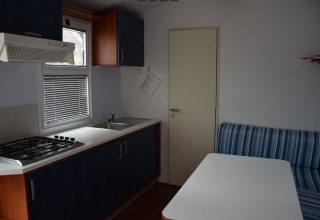 Binnenkant van een glampingverblijf bij Camping Rosental Roz - Stacaravans Oostenrijk met keuken en tafel.