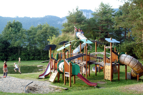 Parque infantil en Camping Rosental Roz - Stacaravans Oostenrijk, niños jugando y toboganes en un entorno natural.