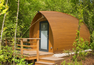 Et moderne glamping-hus ved Glamping Resorts Biosphere Bliesgau, gemt i frodig natur under træer.