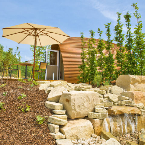 Glampingaccommodatie bij Glamping Resorts Biosphere Bliesgau met houten pod en gezellige terras met parasol.
