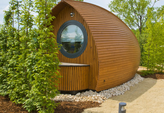 Moderne glamping Unterkunft bei Glamping Resorts Biosphere Bliesgau, umgeben von grüner Natur und Bäumen.