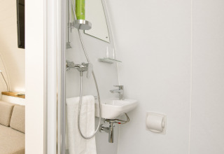 Salle de bain compacte avec douche, lavabo et toilettes dans un hébergement glamping à Glamping Resorts Biosphere Bliesgau.