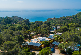 Vista aerea di Camping Bonporteau - Glamping Sud Francia, immerso nella foresta con vista mare sullo sfondo.