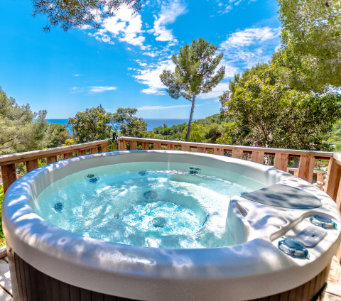 Vasca idromassaggio all’aperto con vista su mare e bosco a Camping Bonporteau - Glamping Sud Francia.