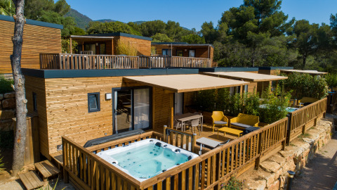 Moderne glampingaccommodatie bij Camping Bonporteau in Zuid-Frankrijk met privéjacuzzi en houten terras.