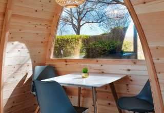Knusse glamping pod met houten wanden, groot raam en moderne zithoek op Natuurpark Camping Prinzenholz.