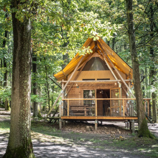 Hébergement glamping en forêt à Huttopia Versailles - Glamping Île de France, cabane en bois chaleureuse en pleine nature.